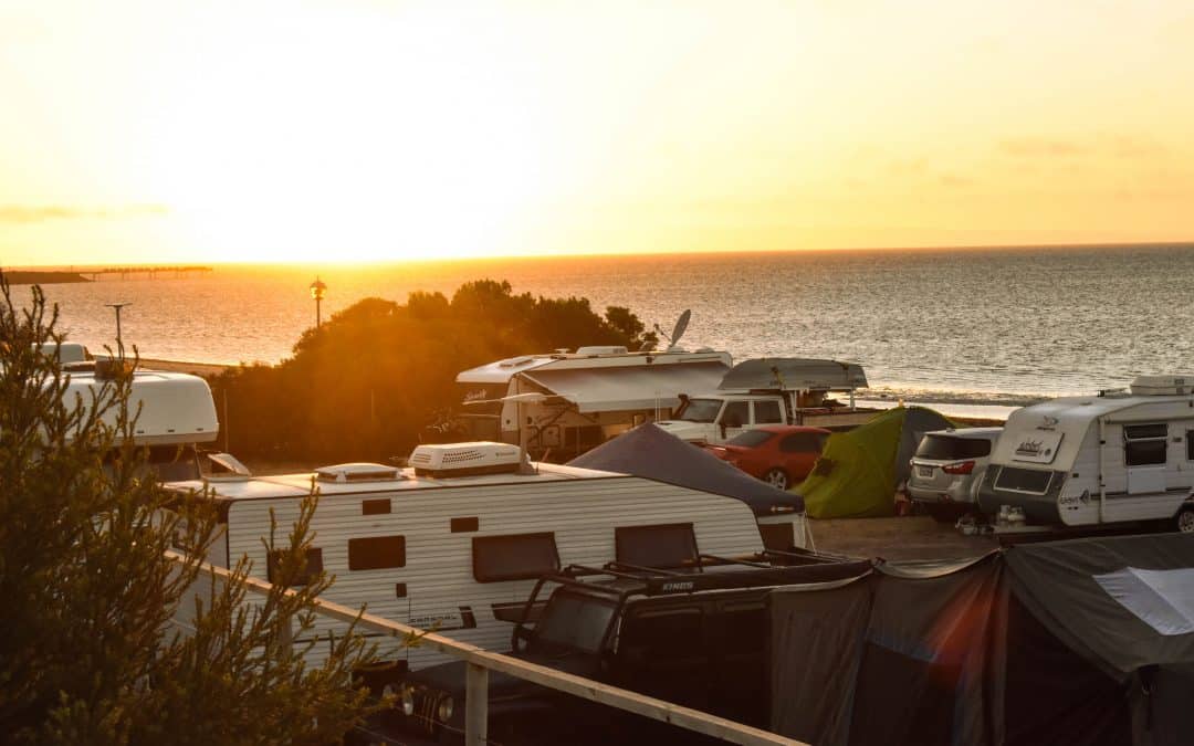 A row of campervans parked by the ocean for a beachfront getaway