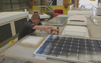 man installing solar panel on the van roof
