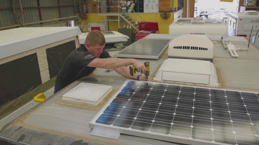 man installing solar panel on the van roof man installing solar panel on the van roof