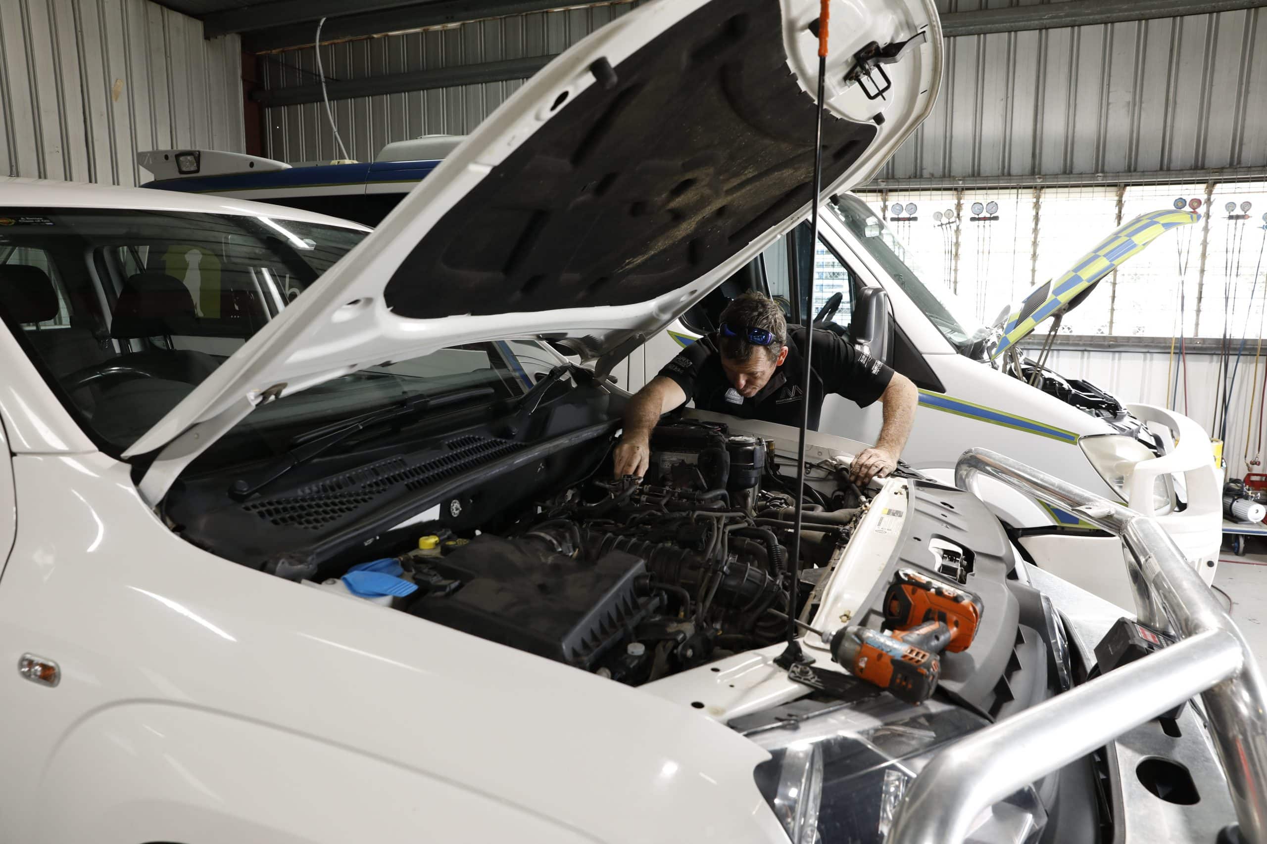 Mechanic diagnoses car troubles: Hood open for repairs inside a workshop