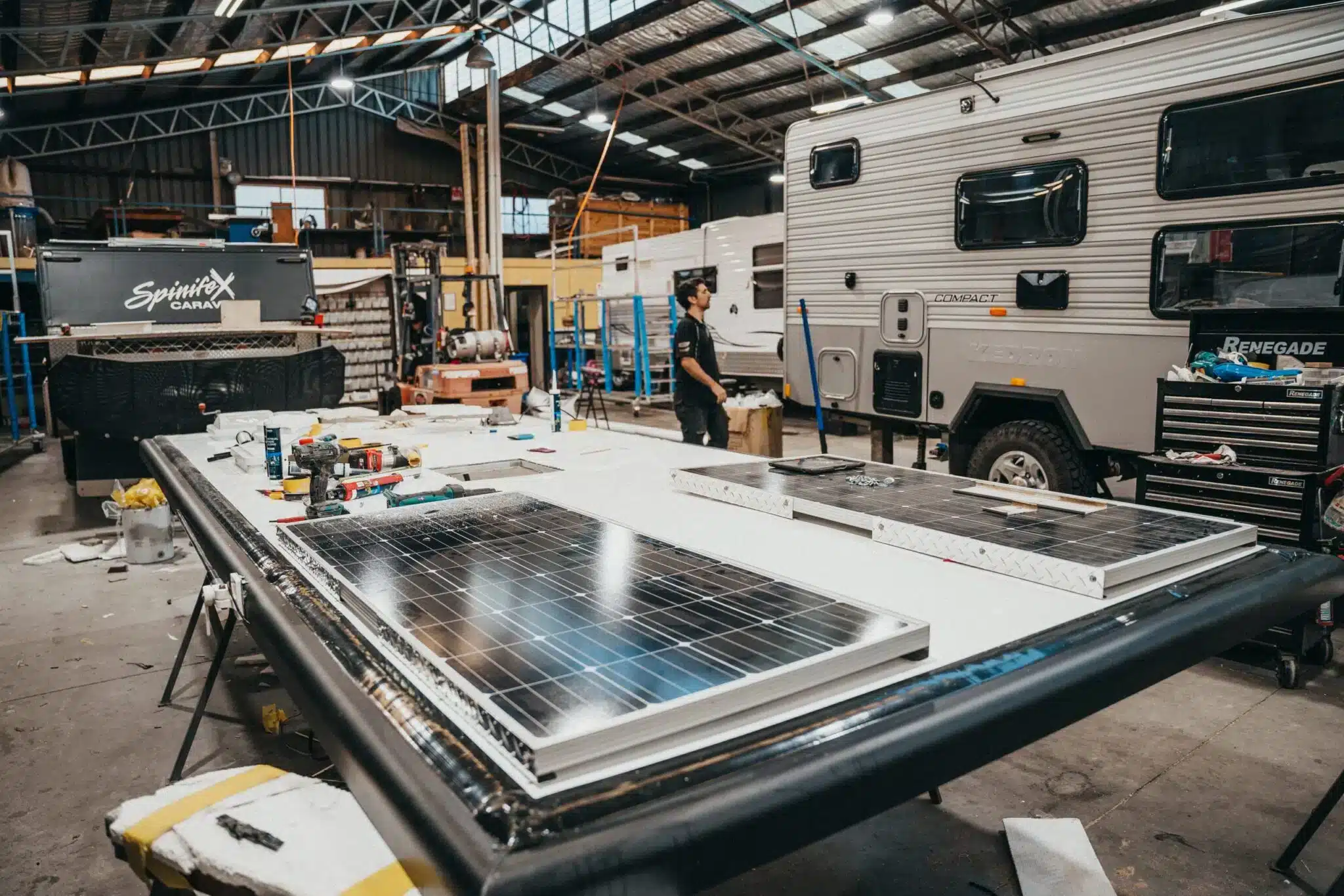 Technician installs solar panels on a caravan roof